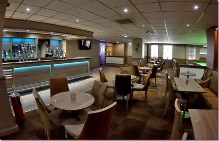Modern club bar with drinks on display and staff ready to serve